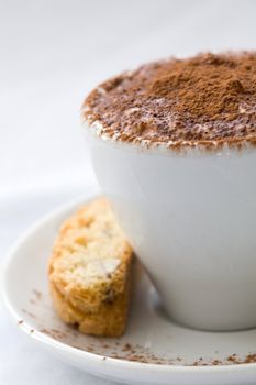 Small chocolate dessert served in a small coffee cup with cookie on the side