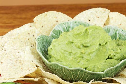 Fresh guacamole and tortilla chips with shallow depth of field.