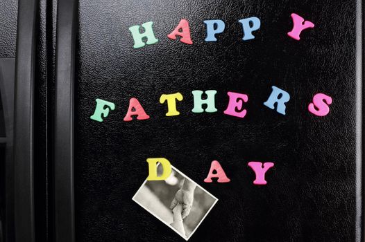 Refrigerator magnets with the message of "Happy Father's Day" and a photo of a father and child holding hands.