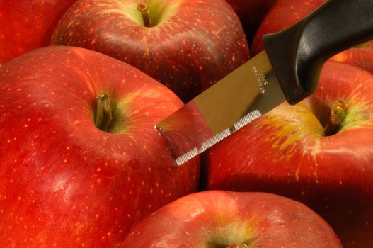Image shows red apples with a stainless steel kitchen knife