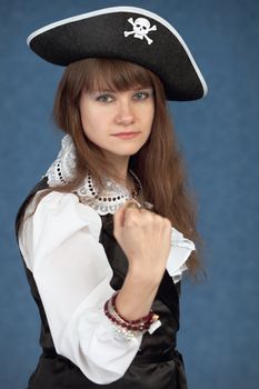 Serious girl in costume of sea pirate on blue background
