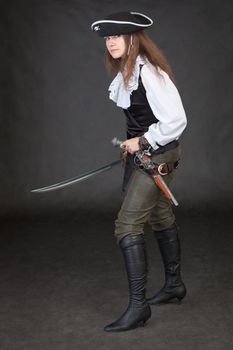Pirate girl with pistol and saber on black background