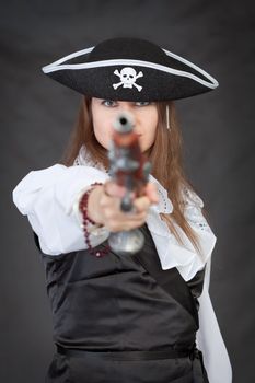 Pirate woman with old pistol on black background