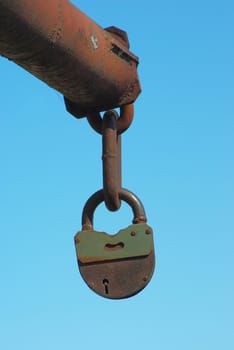 Old closed padlock on the rusty iron gate