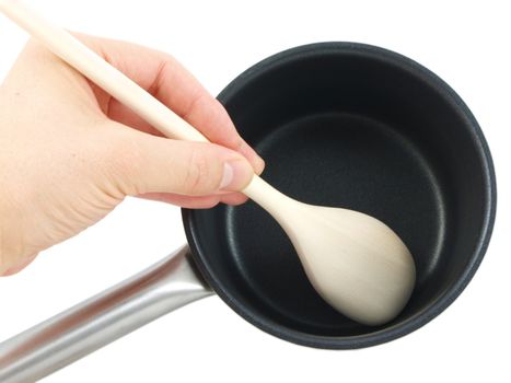 Stainless steel kettle, with wooden spatula and human hand, isolated towards white background