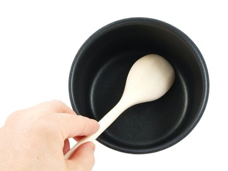 Stainless steel kettle, with wooden spatula and human hand, isolated towards white background