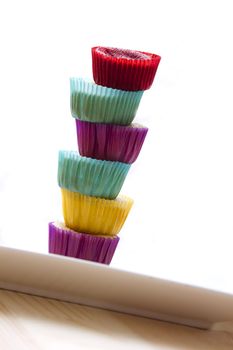 small cupcake in colorful cup place one on top of the other to create a column with a top cupcake