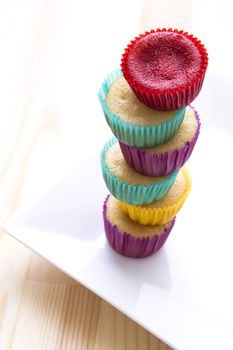 small cupcake in colorful cup place one on top of the other to create a column with a top cupcake