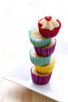 small cupcake in colorful cup place one on top of the other to create a column with a top cupcake with valentine inspire decoration