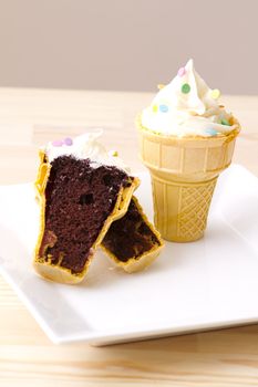 Chocolate cupake in a ice cream cone with a swirl of icing