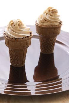 Chocolate cupake in a ice cream cone with a swirl of icing