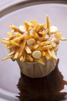 cupcake in a white paper cup decorated to look like a poutine