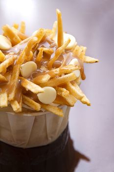 cupcake in a white paper cup decorated to look like a poutine