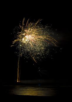 colorful fireworks display with reflection in water
