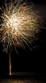 colorful fireworks display with reflection in water