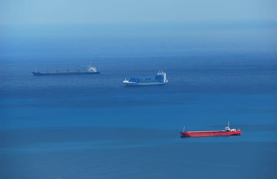 Three cargo ships in blue sea