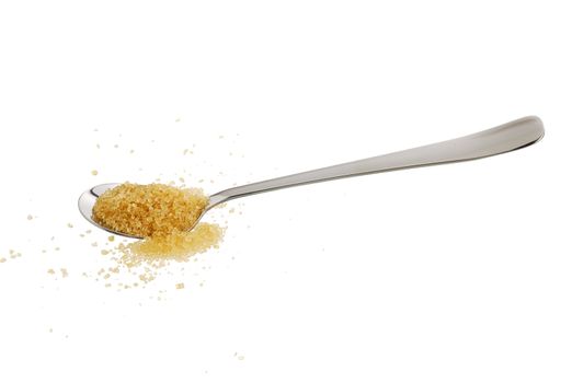 Brown sugar ( golden demerara) spilled from teaspoon isolated on white background