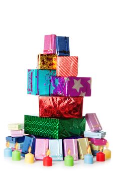 Colorful stack of gift boxes and candles isolated over white background
