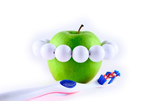 Apple with white beads and tooth-brush, symbolising healthy teeth
