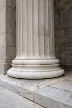 A sinlge white stone column with groves and designs