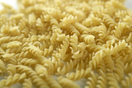 Close-up of italian spiral yellow pasta texture as background