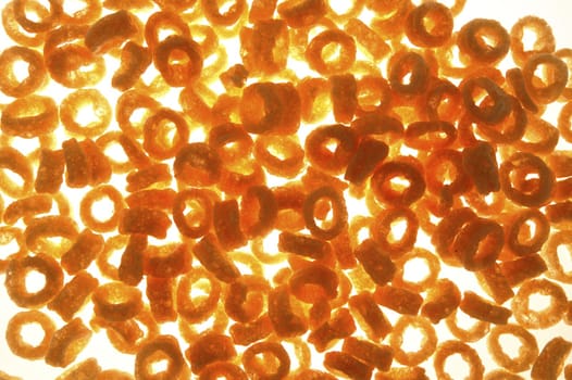 Round corn snack rings texture over transparent white