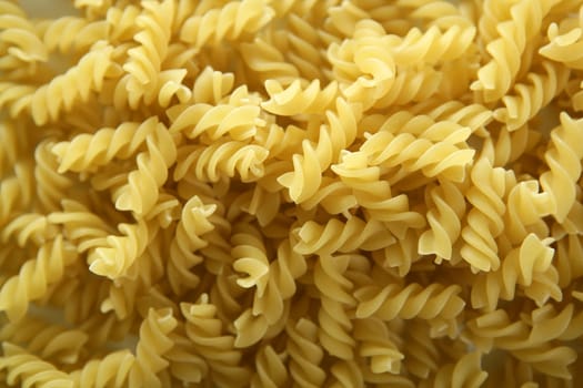 Close-up of italian spiral yellow pasta texture as background