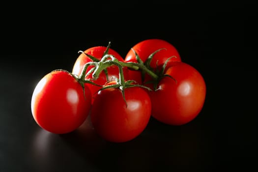 Cluster red tomato over dark black background