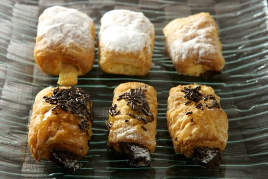 Six cream and chocolate pastries dish in two rows