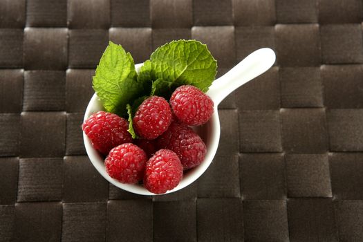 Raspberries with basil leaves, fresh natural dessert