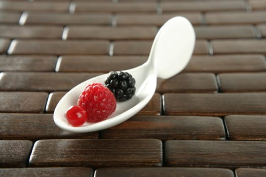 Berries in a white spoon, wooden background