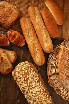 Varied bread still life over dark wood background