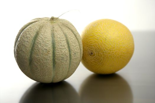 Two melon fruit over a stainless steel table