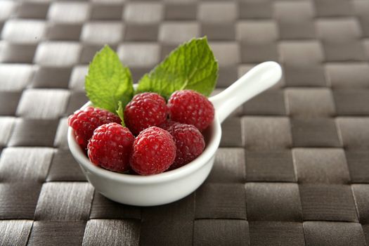 Raspberries with basil leaves, fresh natural dessert