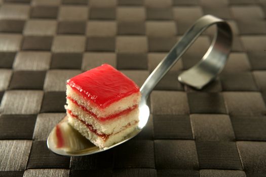 Varied pastries over spoon. Little colorful cakes