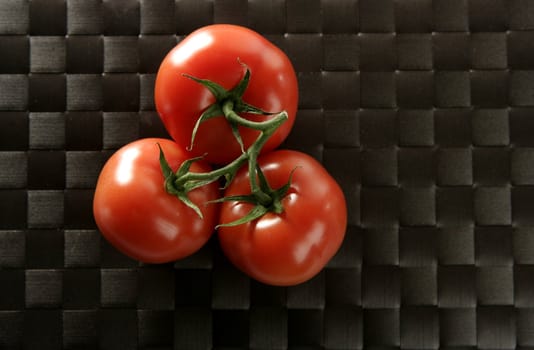 Three red tomatoes in the same one branch