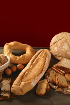 Bread still live over dark wood background, varied shapes