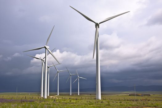 Wind turbines generating electricity in a stormy weather.