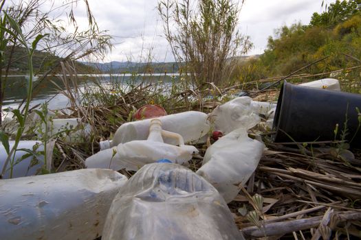 A huge pile of plastic garbage of all sorts in the river, ecology issue.