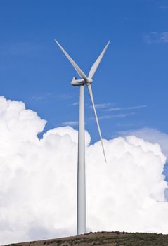 Wind turbine generating electricity with a nice white cloud on the sky