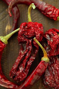 Red dried hot chili peppers over a dark wood background