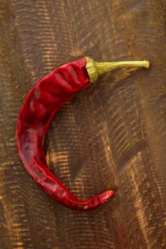 Red dried hot chili pepper over a dark wood background