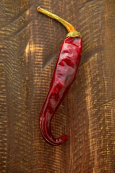 Red dried hot chili pepper over a dark wood background