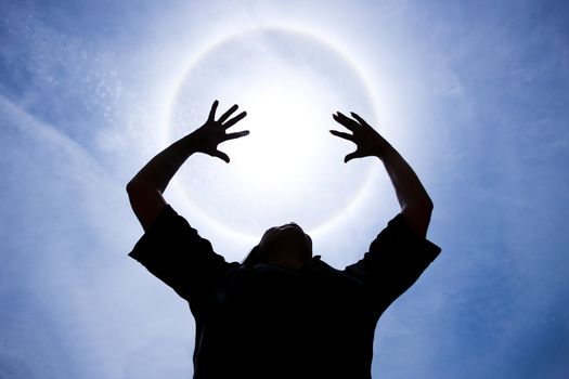 person with hands up around Halo - sunlight  phenomenon