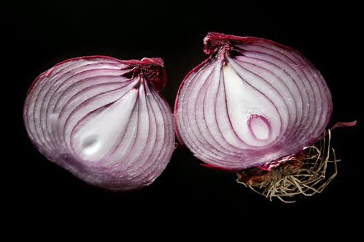 Red onion sliced in two parts over black background