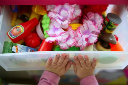 Girl hands closing her box toy container, pushing the messy inside