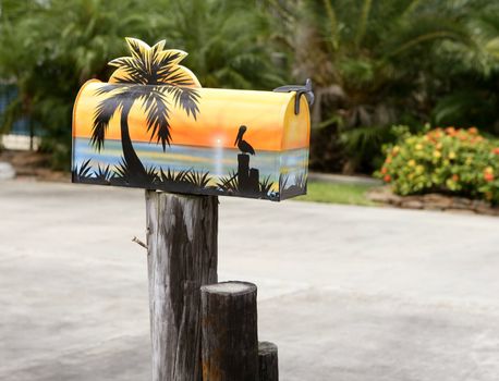 Fun artistic mail box with tropical sea paint, palm tree sunset