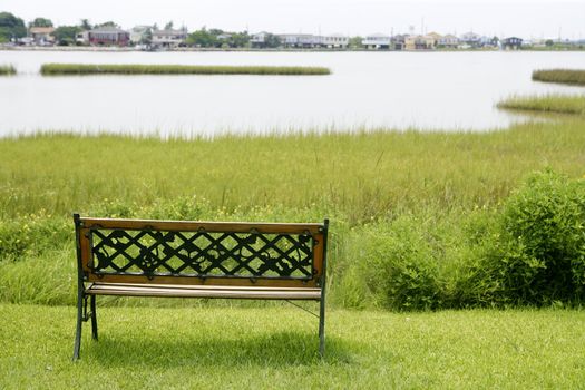 Bench over the green grass on the lake, peace metaphor