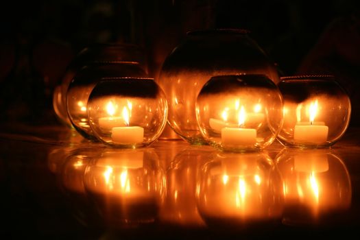 Candlelight of candles in round glasses decoration over black background