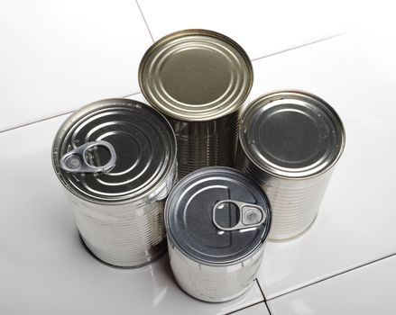 four silver food cans, one can on it's side show the ring pull on the lid
